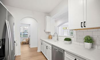 A modern kitchen with white cabinets and a dishwasher.