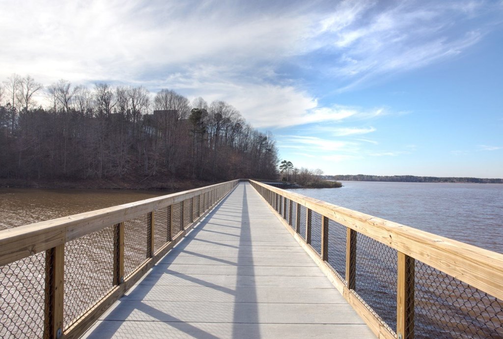 A wooden boardwalk extends into the distance over a body of water.