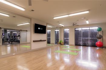 A gym with a mirror, exercise balls, and yoga mats.