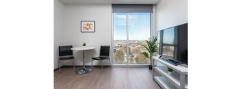 a living room with a large window and a table with chairs and a television