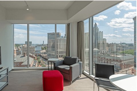 a living room with a view of the city and a table and chairs