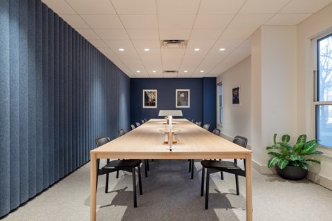 A conference room with a long table and chairs.