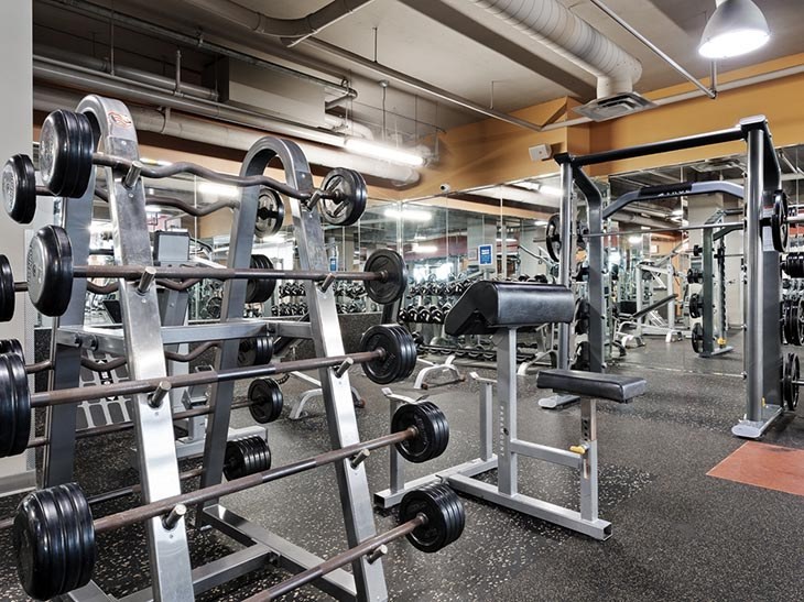 A gym with a weight rack and weights.