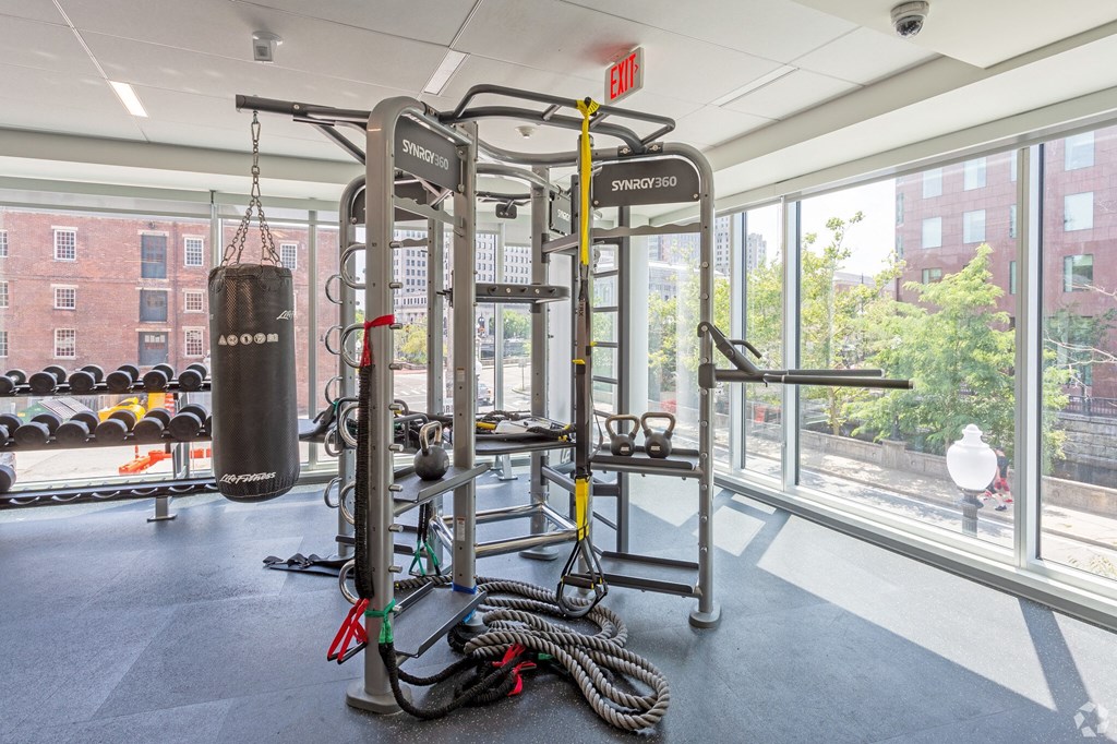 a gym with weights and a punching bag in a window