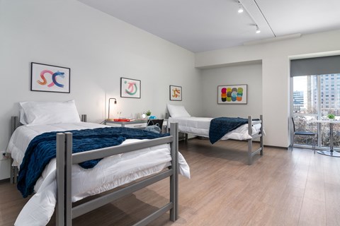 two beds in a room with a city view