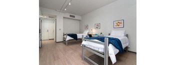 a bedroom with two beds and a door to a bathroom