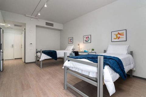 a bedroom with two beds and a door to a bathroom