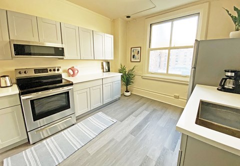 A kitchen with a stove, oven, and microwave.