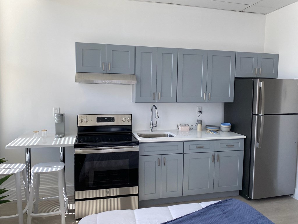a kitchen with blue cabinets and stainless steel appliances and a table and chairs