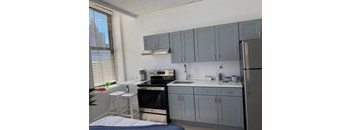 a kitchen with gray cabinets and a stove and a refrigerator