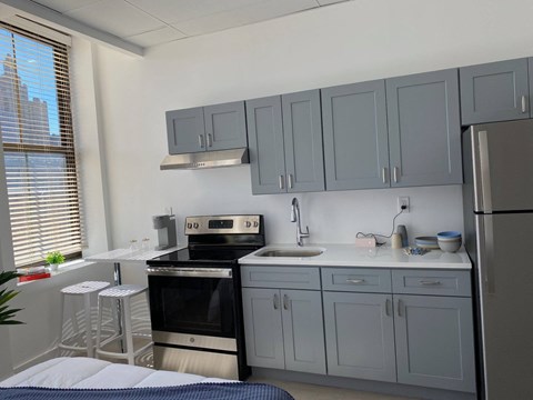 a kitchen with gray cabinets and a stove and a refrigerator
