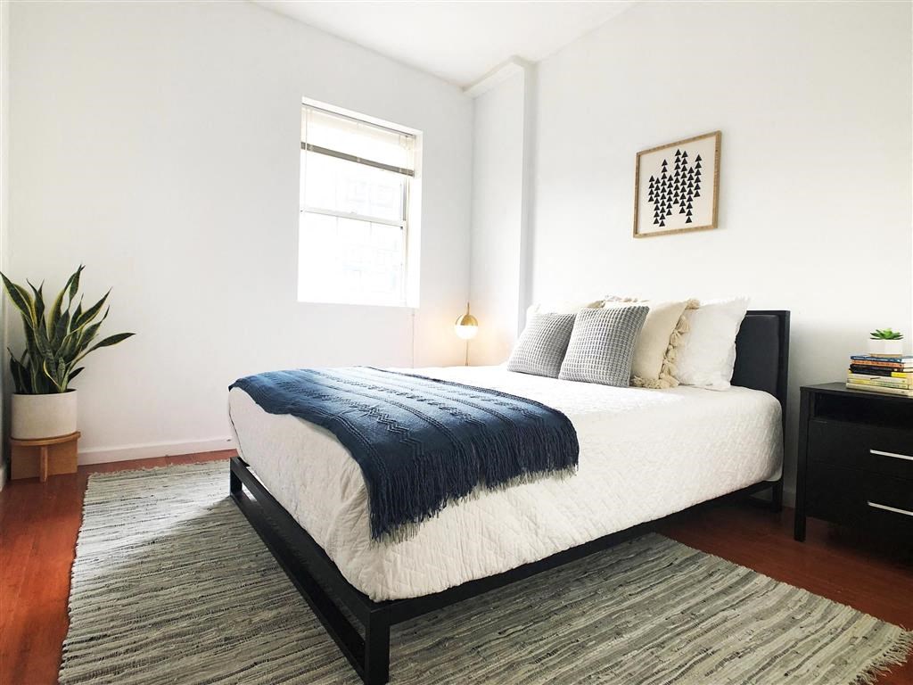 a bedroom with a bed and a window