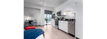 a bedroom with a bed and a kitchen with a sink