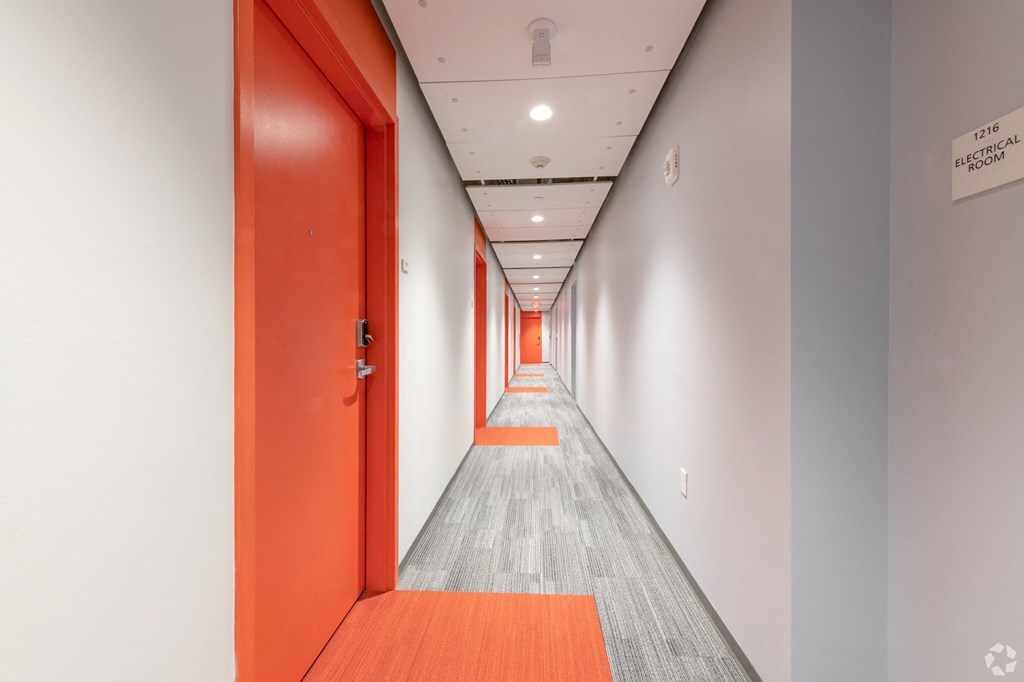 a long corridor with red doors and white walls