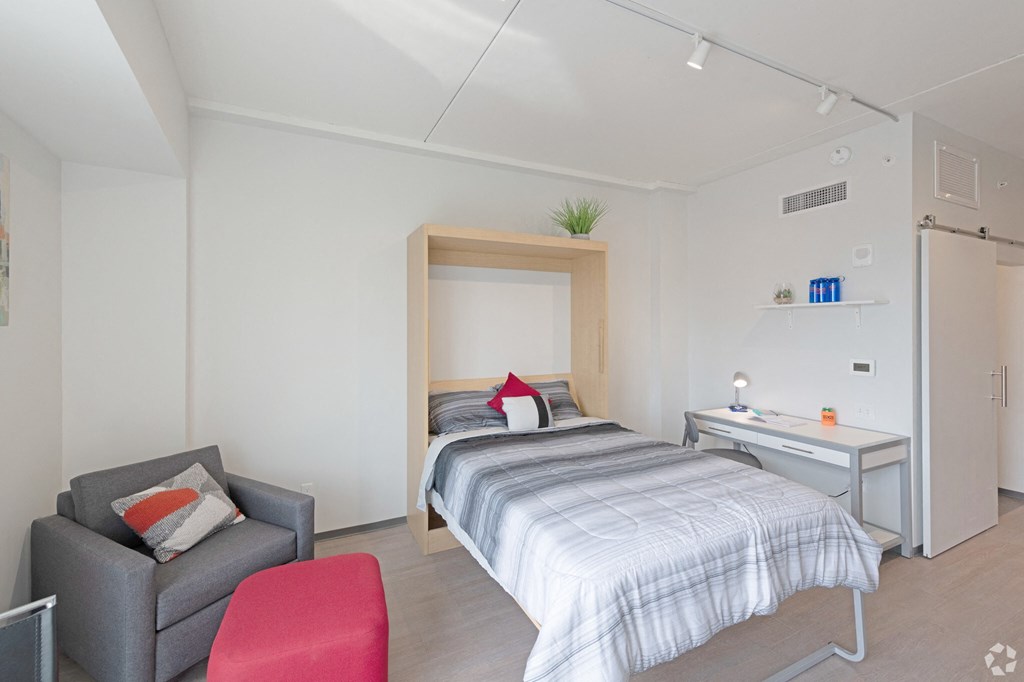 a bedroom with a bed and a desk and a chair