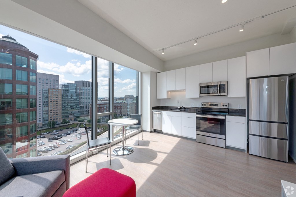 a living room with a kitchen and a large window