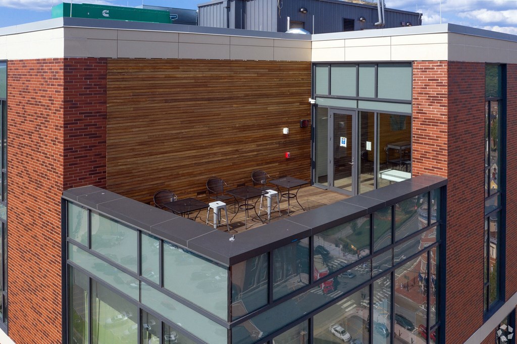 an aerial view of the top of a building with tables and chairs on a balcony