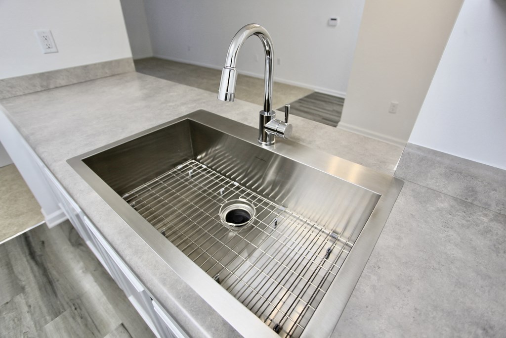 a stainless steel sink with a chrome faucet in a kitchen