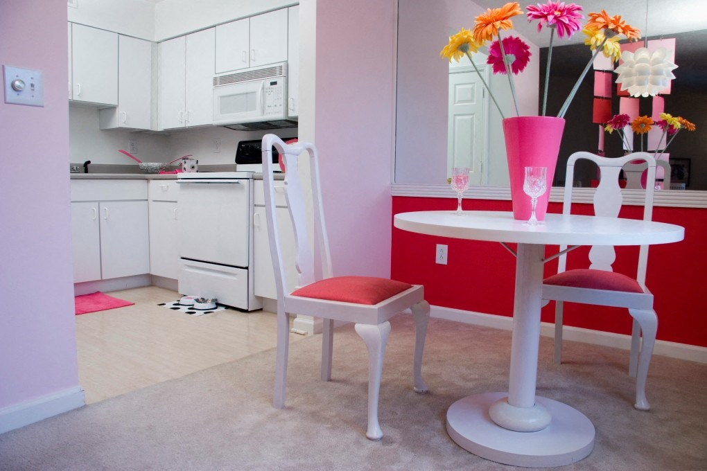 a white kitchen with a small table and chairs