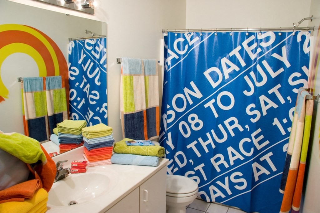 a bathroom with blue and white shower curtains and a sink and a toilet
