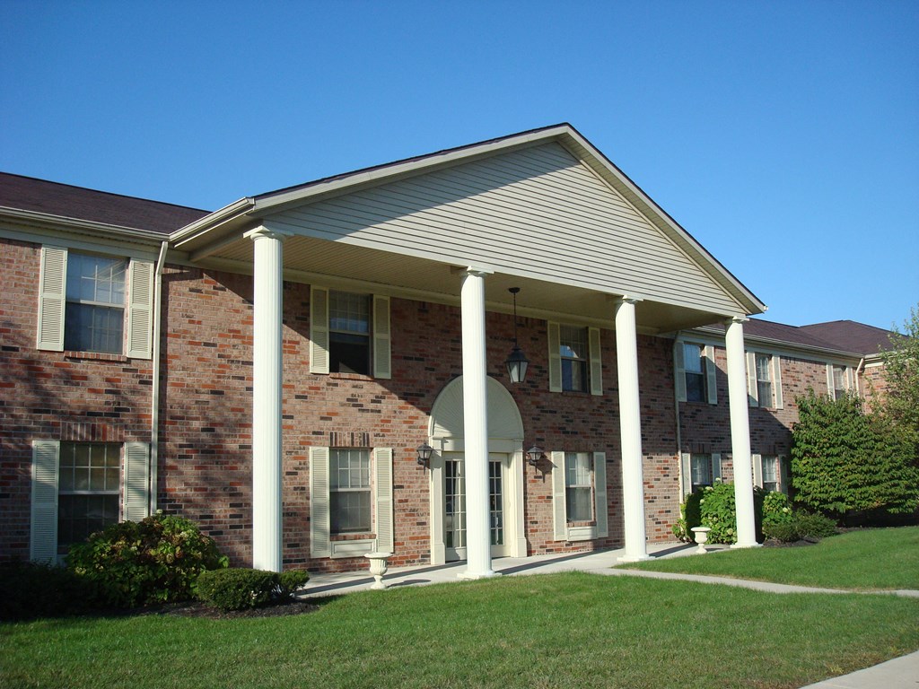 the front of a brick building with columns