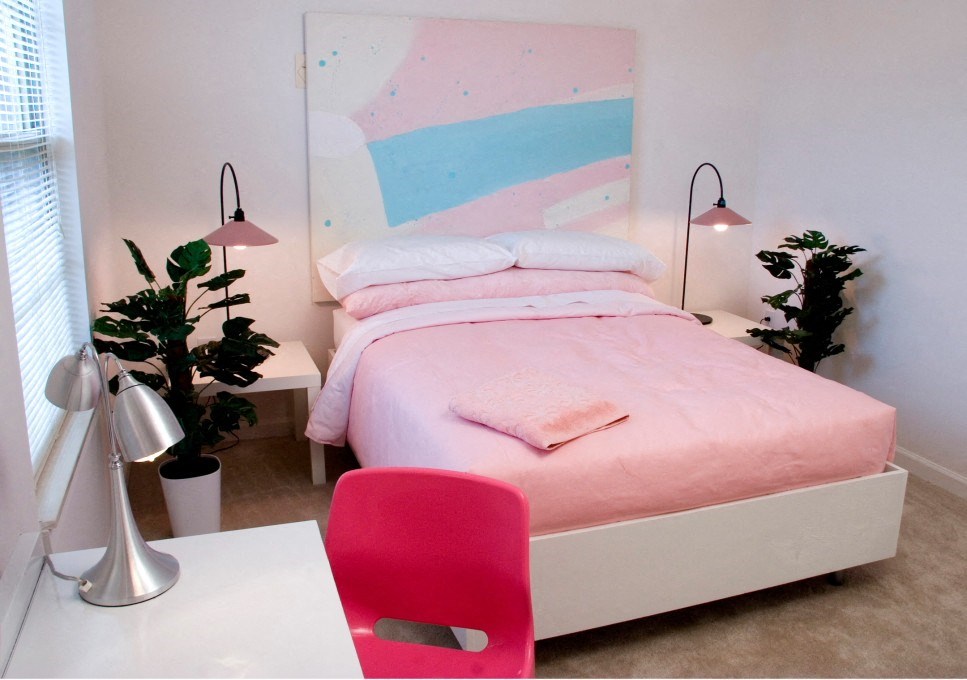 a bedroom with a bed and a desk with a red chair