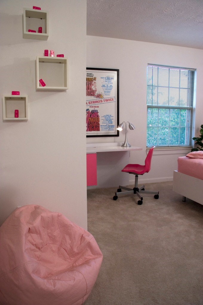 a patient room with a pink chair and desk and a window