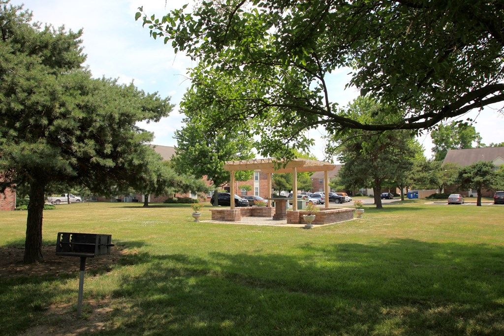 a park with a pavilion in the middle of a grass field