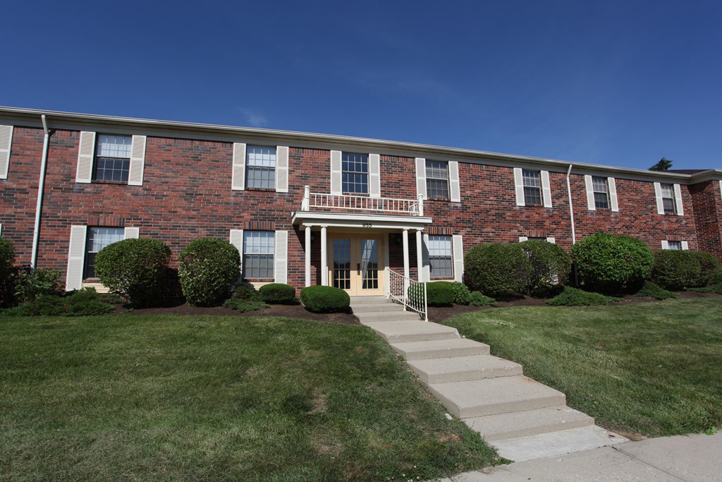 the front of a brick building with stairs in front