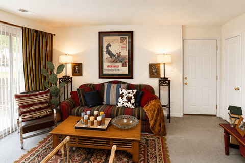 A living room with a couch, chair, and a painting on the wall.