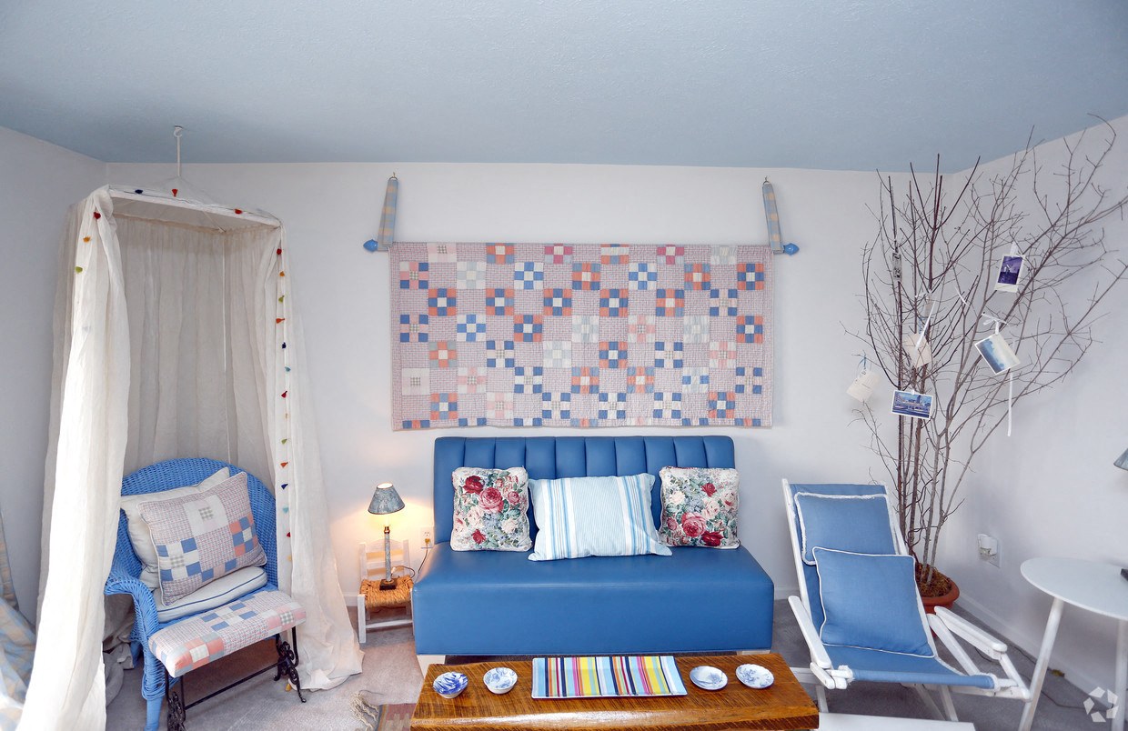 a living room with a blue couch and a futon