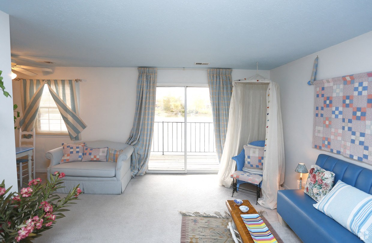 a living room with blue furniture and a sliding glass door