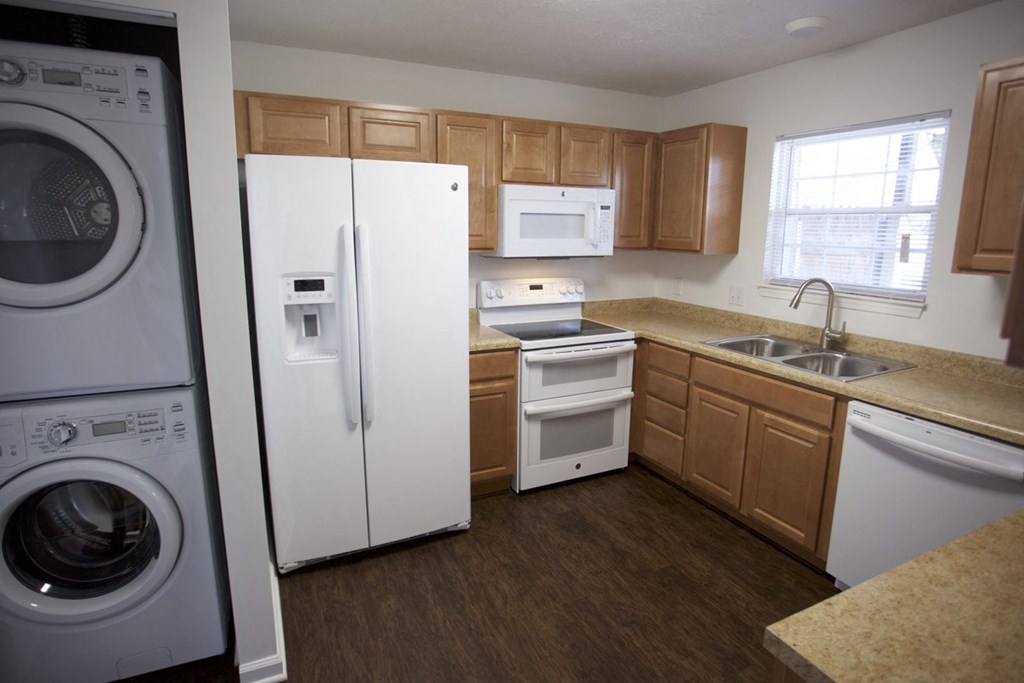 a kitchen with a washing machine and a refrigerator