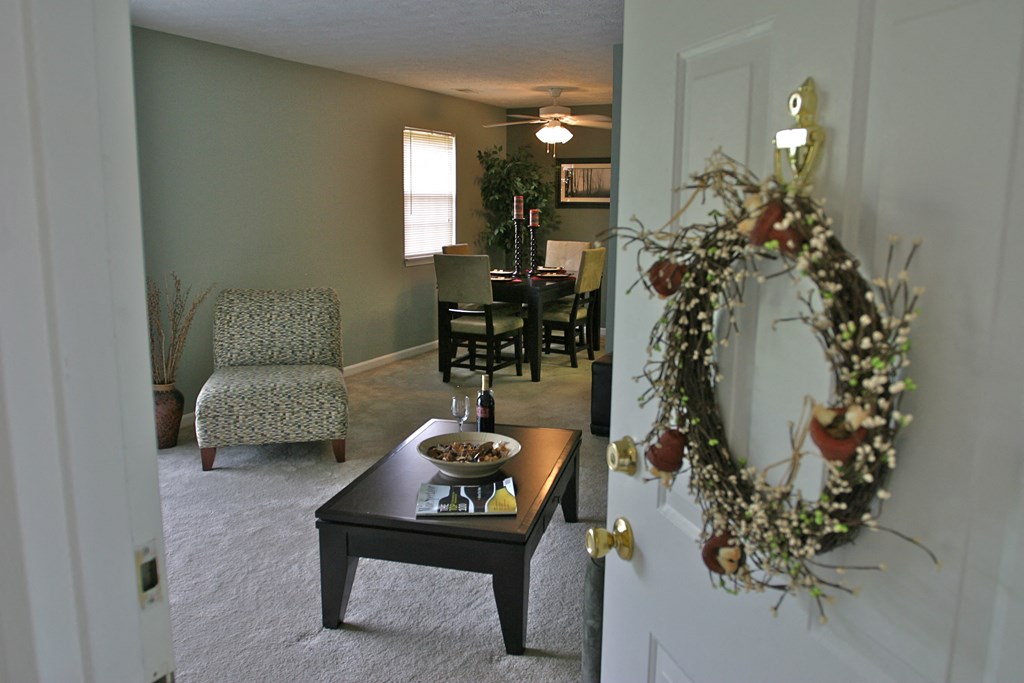 a living room and dining room with a wreath on the door