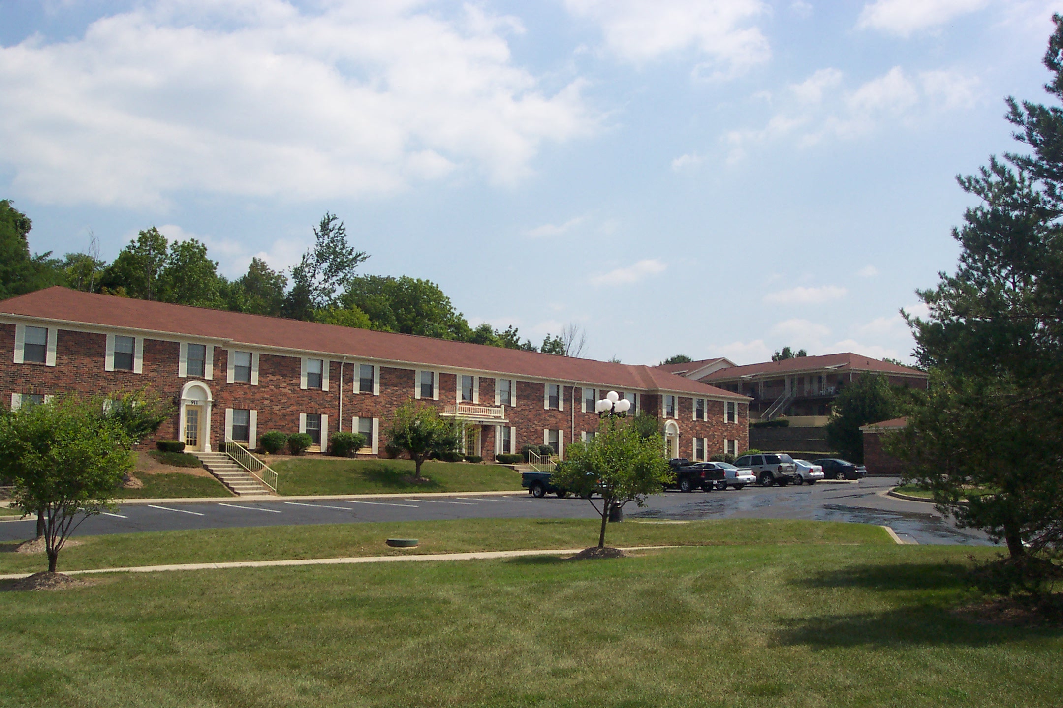 a large brick building with cars parked in a parking lot