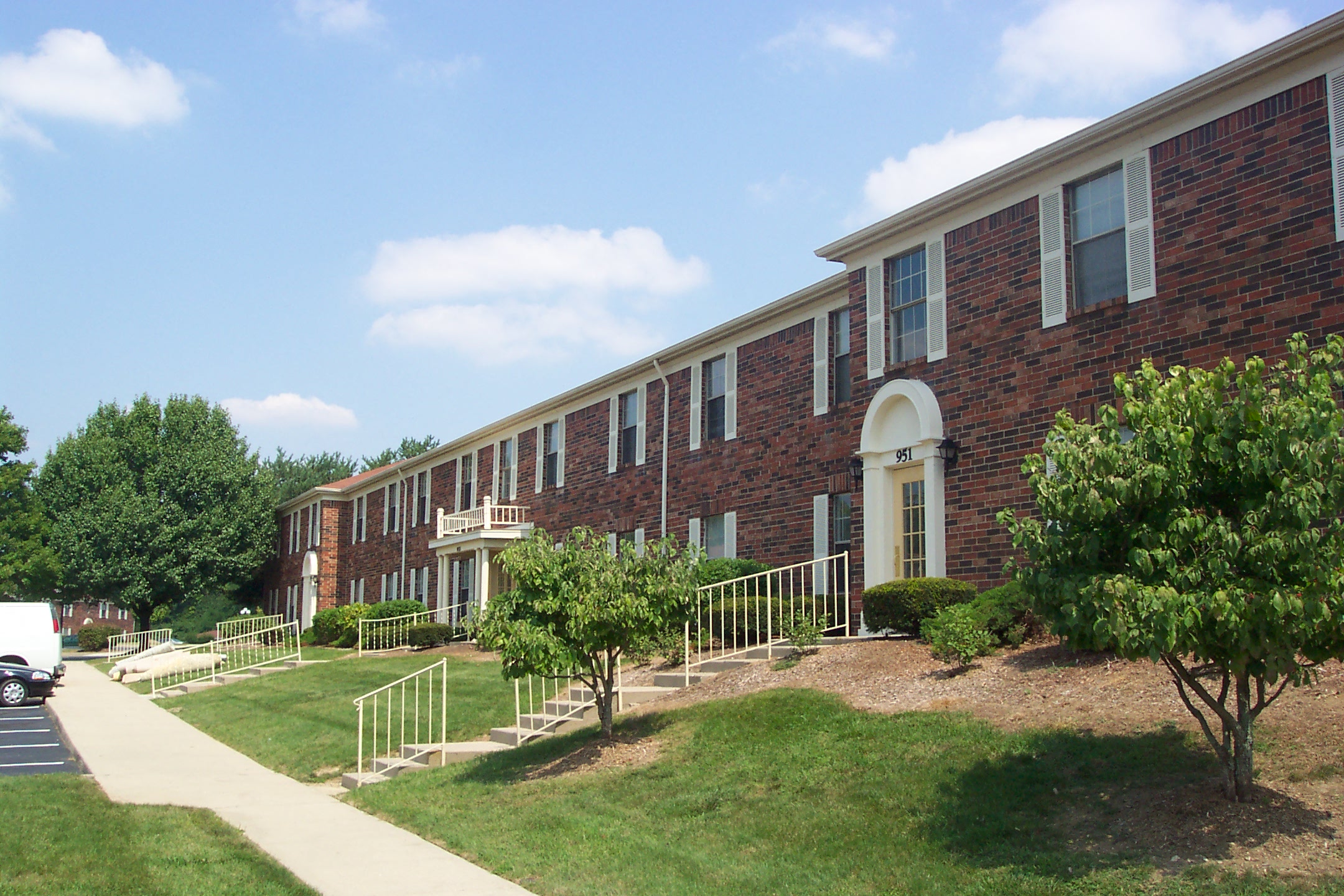 an exterior view of a brick building with lawn and trees