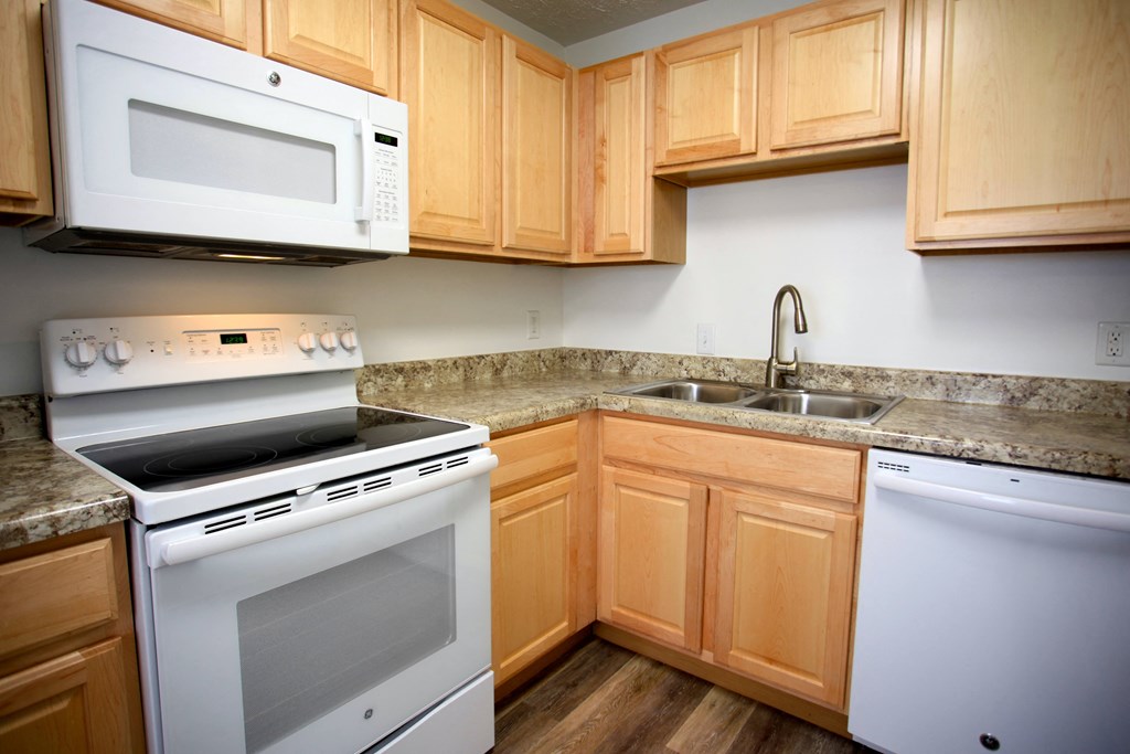 a kitchen with white appliances and wooden cabinets