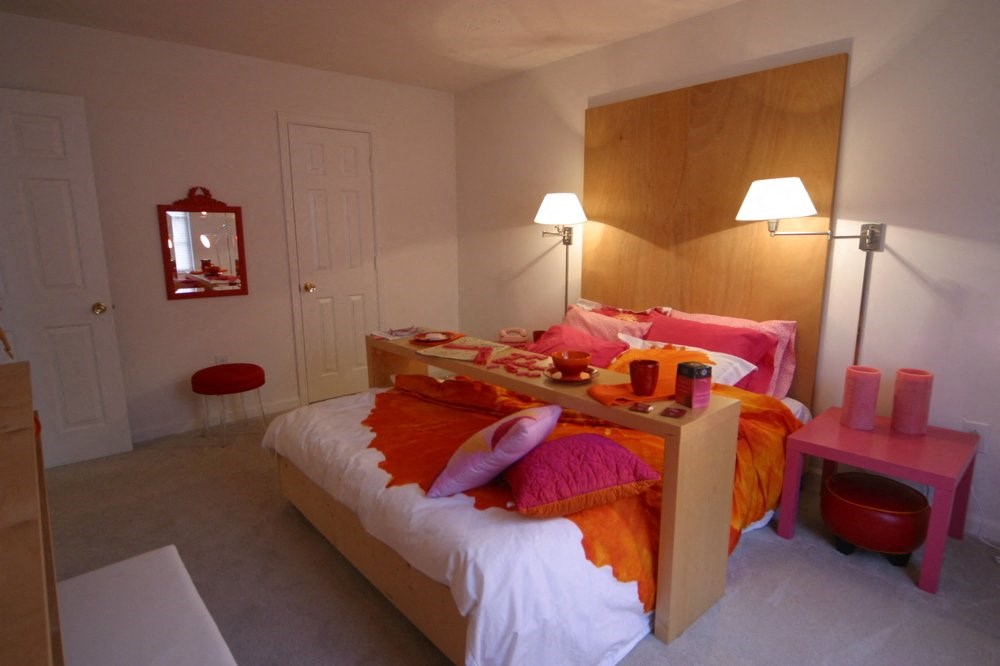 a bedroom with a bed and a desk and a mirror