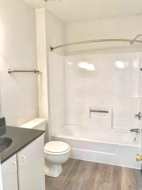 a white bathroom with a toilet and a shower