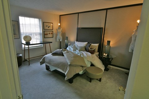 a bedroom with a bed and a dresser and a window