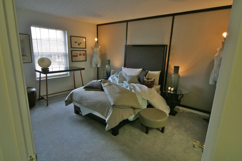a bedroom with a bed and a dresser and a window