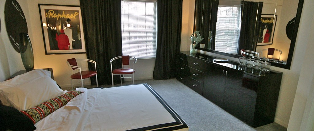a bedroom with a bed and a dresser with a mirror