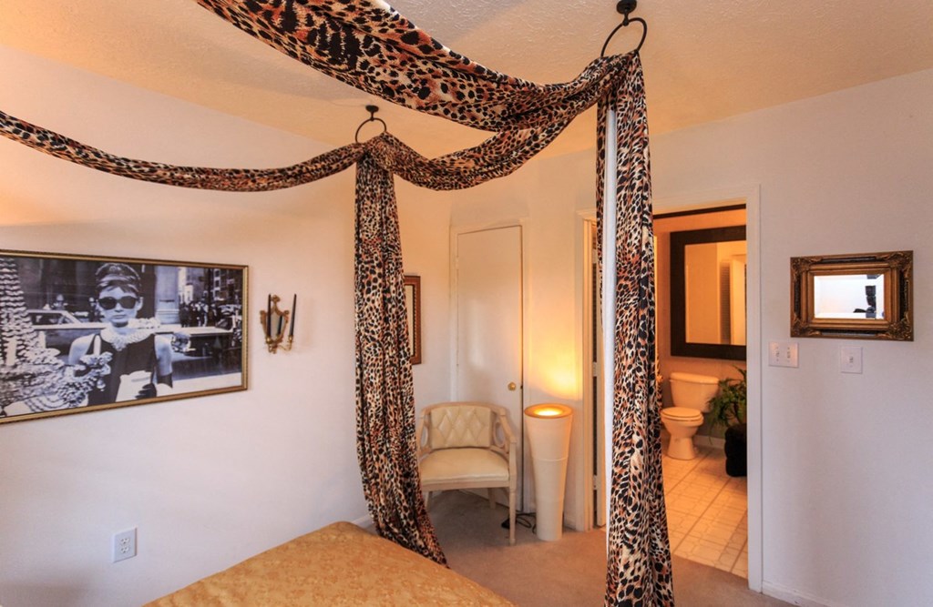 a bedroom with a bed and a drape on the ceiling