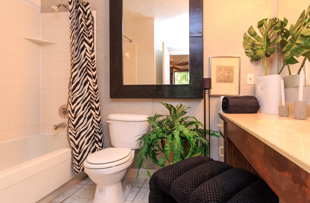 a bathroom with a white toilet and a black and white shower curtain