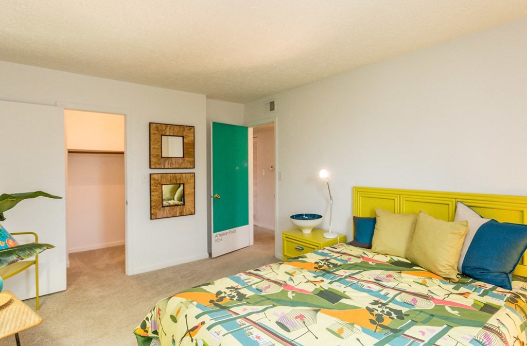 a bedroom with a bed and a dresser and a closet