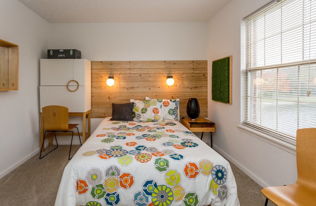 a bedroom with a bed with a colorful comforter