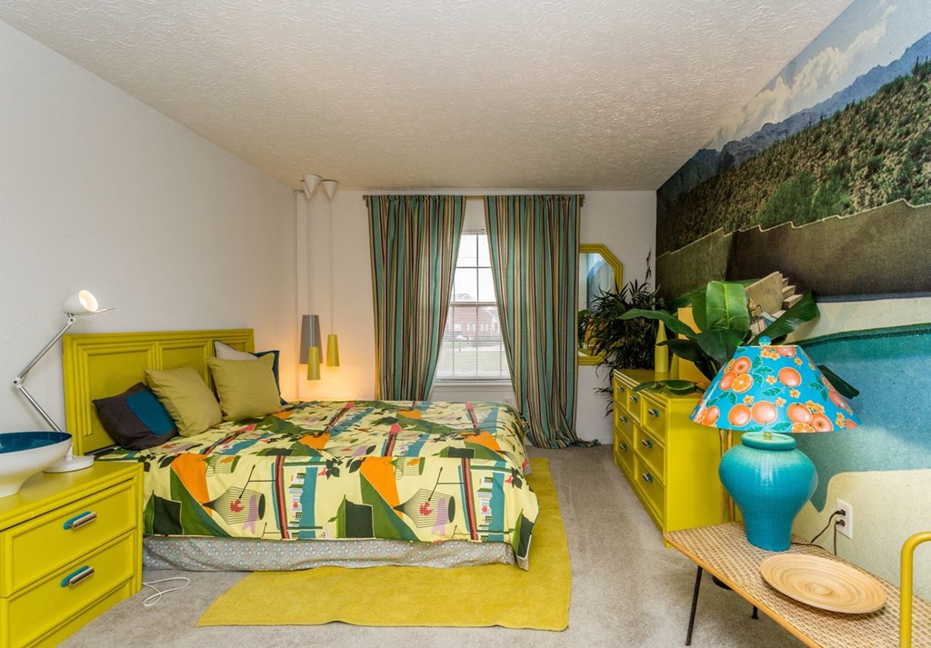 a bedroom with a bed and a painting on the wall