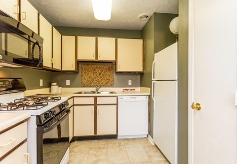 a kitchen with white cabinets and a stove and a refrigerator