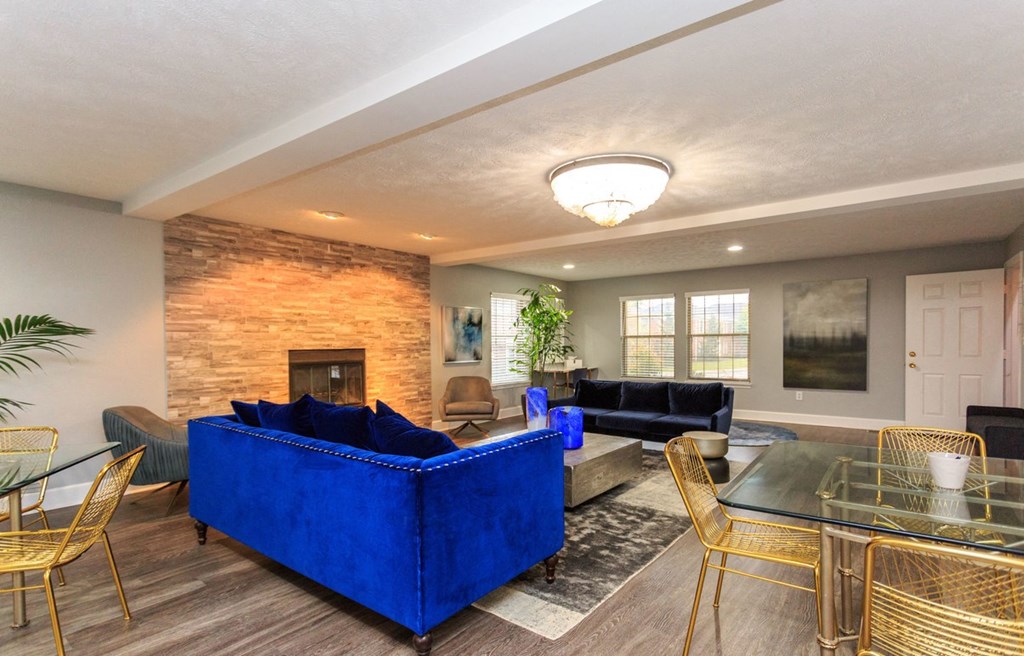 a living room with blue couches and a table and chairs
