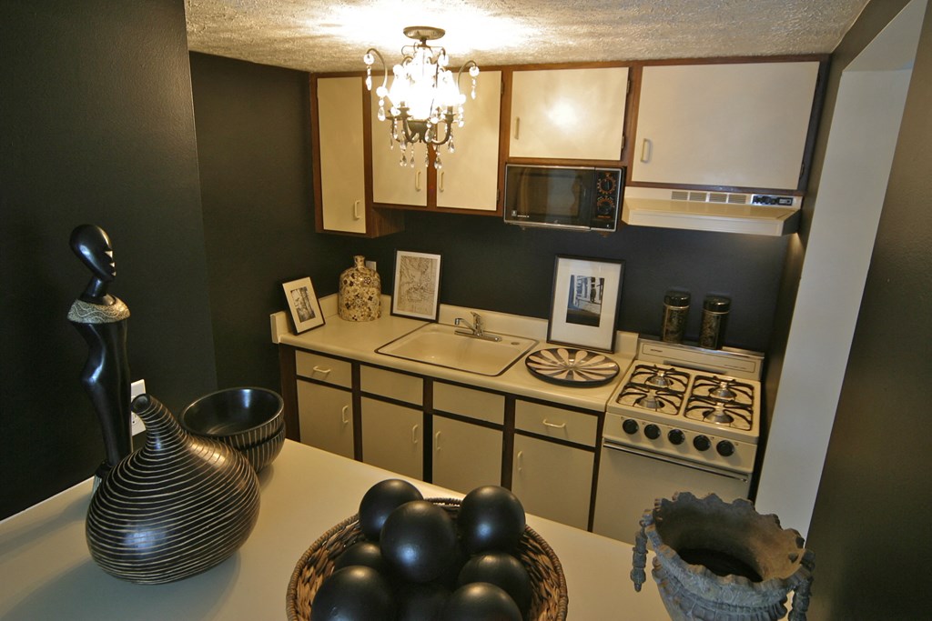 a kitchen with a stove and a sink and a chandelier